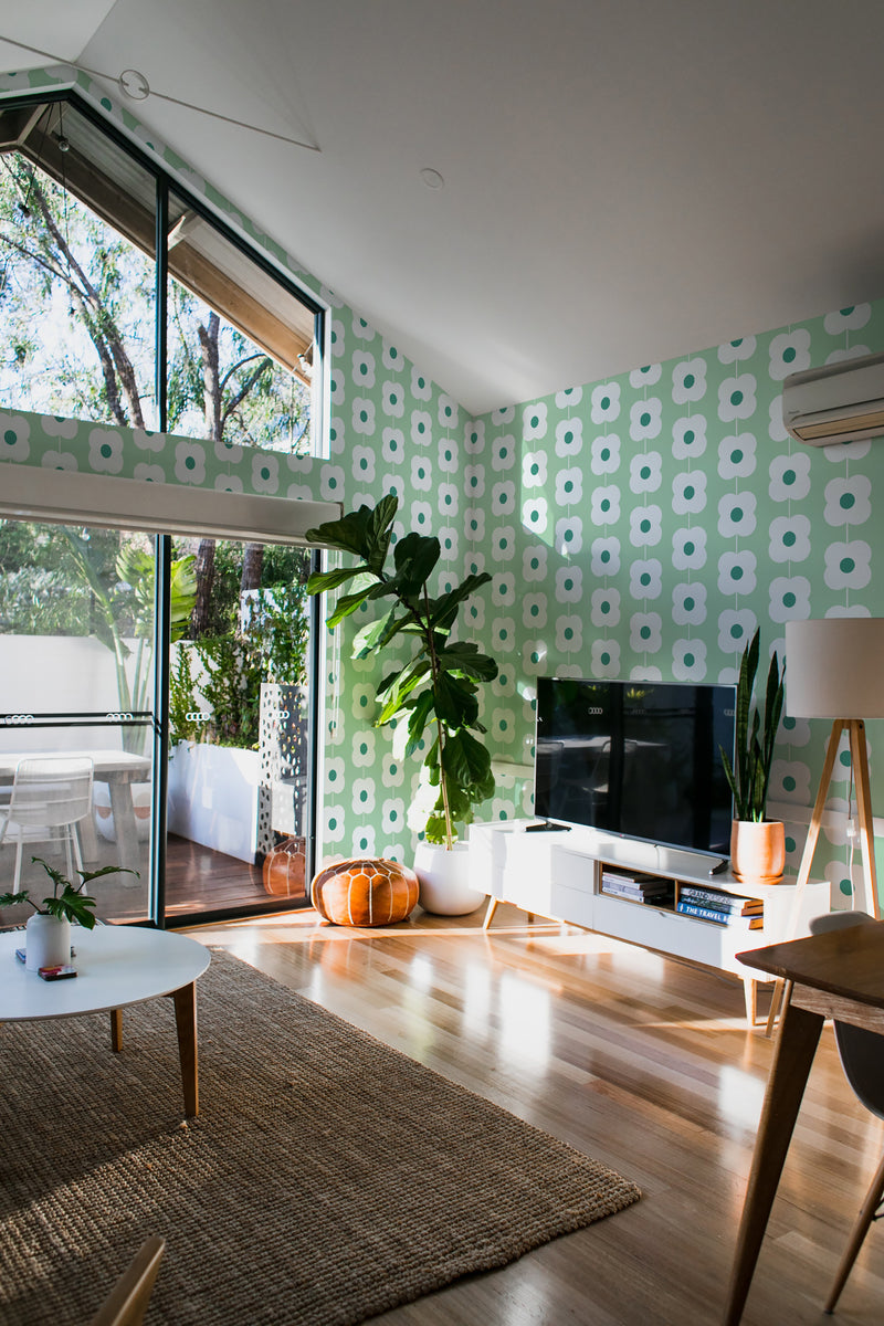 Green retro floral line wallpaper with a repeating pattern of white, geometric flowers accented by light green backgrounds, adding a nostalgic and vibrant touch to the room. Traditional wallpaper.