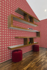 A room with wallpaper in a Red Stones pattern, where red circular shapes are arranged in a grid with contrasting white backgrounds, creating a bold, vintage feel. Traditional wallpaper.