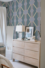 A room with walls adorned in a Purple blue tile patterned wallpaper, consisting of geometric shapes in shades of purple and blue, creating a sophisticated and traditional wallpaper.