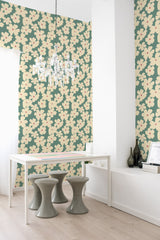 A room with mint green wallpaper adorned with a repeating pattern of cream and peach floral motifs, accompanied by sage green leaves, providing a soft, traditional wallpaper ambiance.