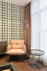 A room with a wall covered in farmhouse plaid wallpaper with green vertical stripes intersecting with thinner horizontal lines, complemented by solid curtains, traditional wallpaper.