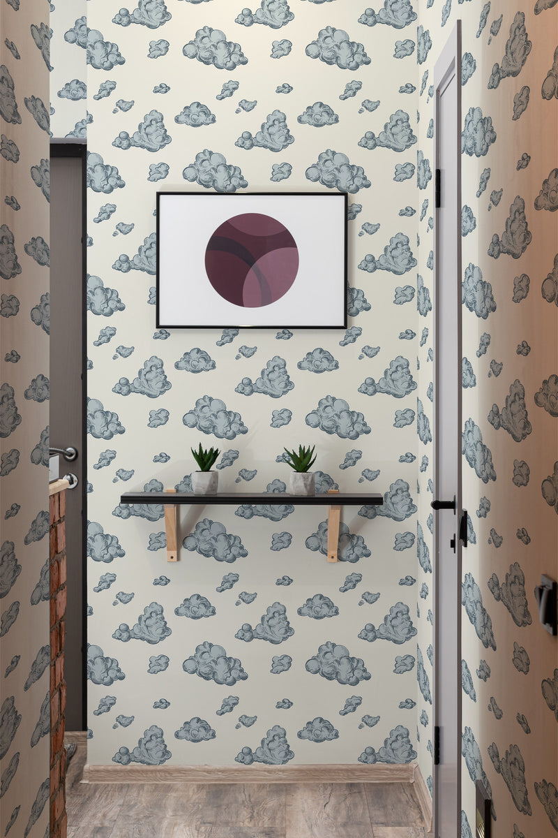 A cozy room corner with walls covered in Vintage clouds design traditional wallpaper, with fluffy cloud motifs in various shades of blue and grey on a neutral background.