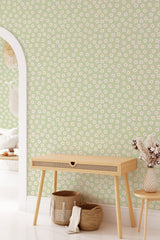 A light-green wallpaper with a pattern of small white daisies framed by tiny leaves, giving a fresh, springtime feel to the room's decor, traditional wallpaper.