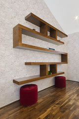 A room with a wall covered in subtle, neutral-toned wallpaper with intricate nature-inspired line drawings, complemented by wooden shelves and red stools, reflecting a traditional wallpaper style.