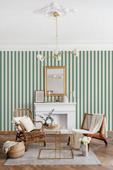 A room with green and white striped wallpaper, a white fireplace, elegant gold-framed mirror, and stylish seating arrangements under a decorative ceiling fixture, exemplifying traditional wallpaper.