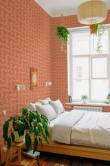 A bedroom with bright pink wallpaper adorned with an orange retro circles pattern, adding a vibrant, vintage charm to the space as traditional wallpaper.