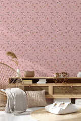 Pink wallpaper adorned with ballerina silhouettes in various dance poses, adding a whimsical touch to the room's decor in a traditional wallpaper style.