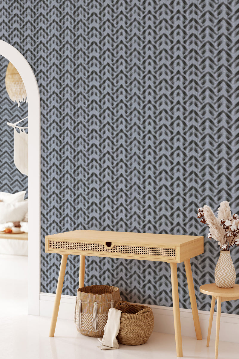 A room with abstract chevron pattern wallpaper in grey tones, offering a modern twist on traditional wallpaper.