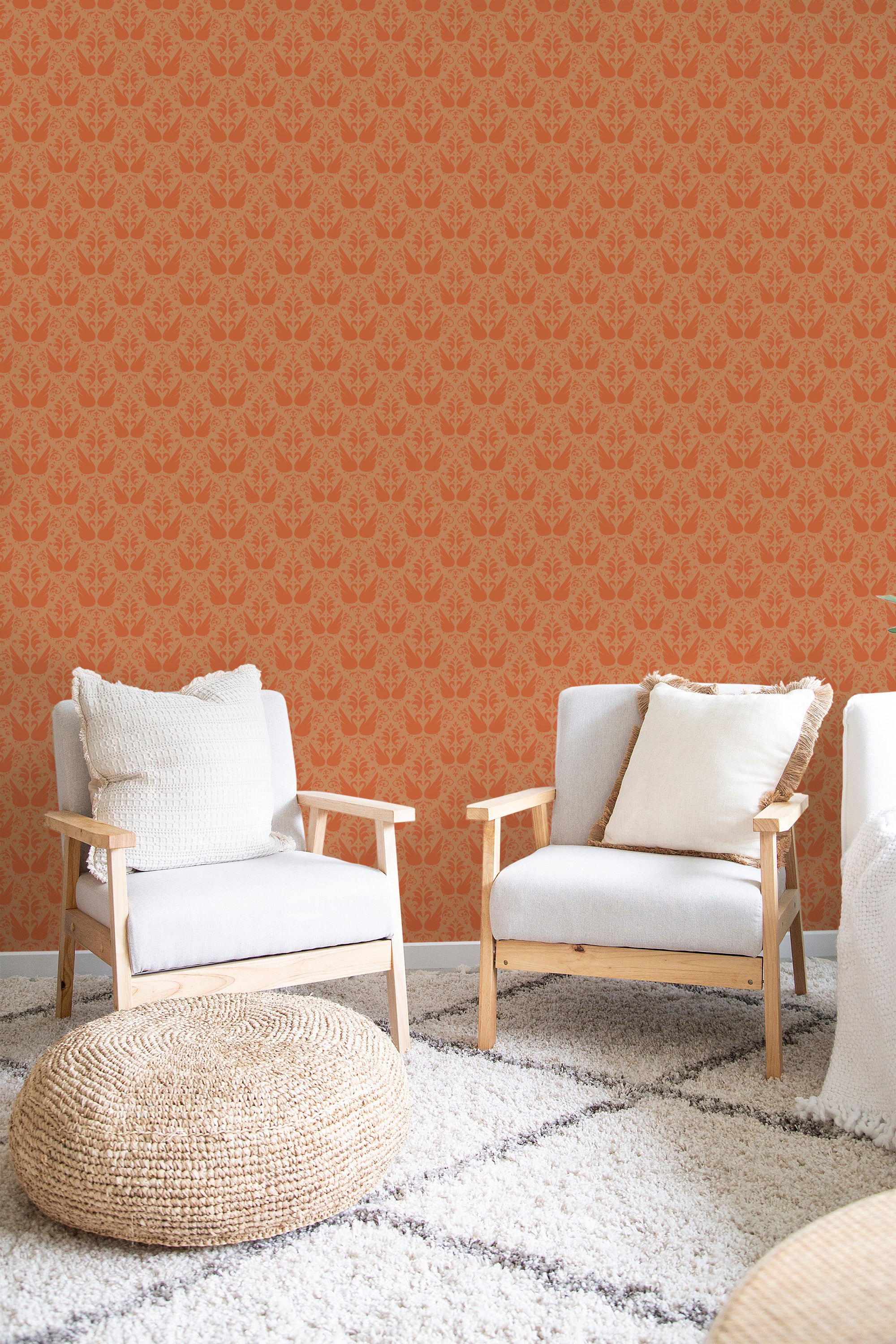 A room with orange wallpaper with a swan pattern, complemented by wooden furniture and a cozy, white cushioned seating area, traditional wallpaper.