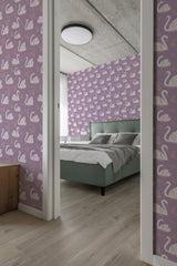 A room with purple wallpaper adorned with repeating white swan motifs, complementing a green bed, traditional wallpaper.