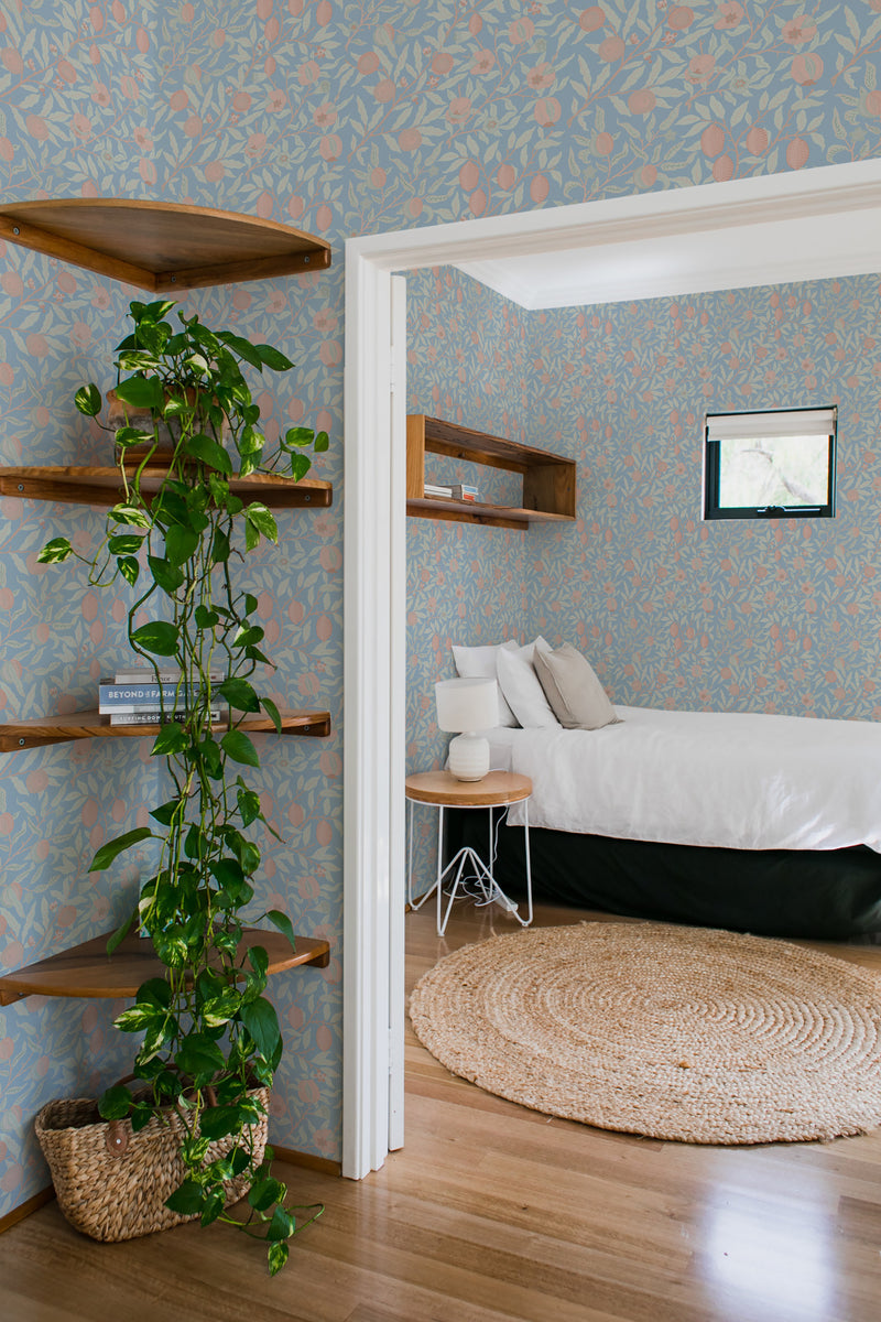 A cozy bedroom with walls covered in a Lemon grove patterned traditional wallpaper.