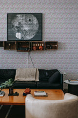 A cozy room with walls covered in leaf and flower patterned traditional wallpaper.