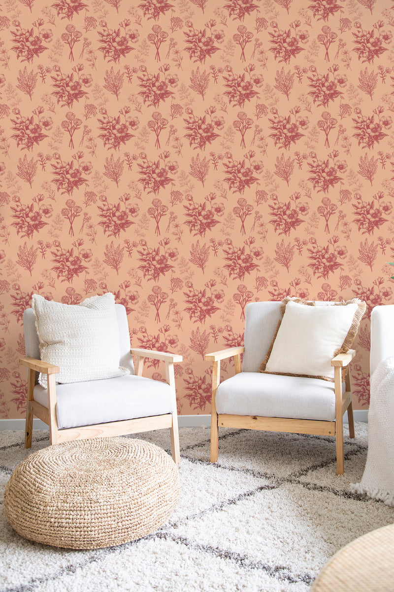 A room with peach-colored walls covered in a repeating pattern of small, burgundy delicate flowers, providing a classic and traditional wallpaper look.