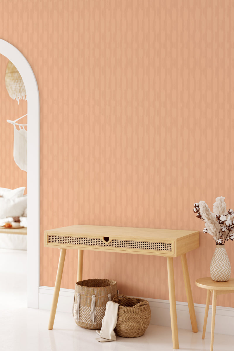 Peach-colored wallpaper with subtle brushstroke texture pattern in a room, complemented by a wooden console table, traditional wallpaper.