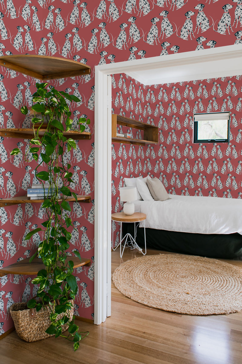 Burgundy wallpaper with a pattern of white dalmatian spots and motifs lining the walls of a cozy room with wooden floors and furniture, evoking a traditional wallpaper style.