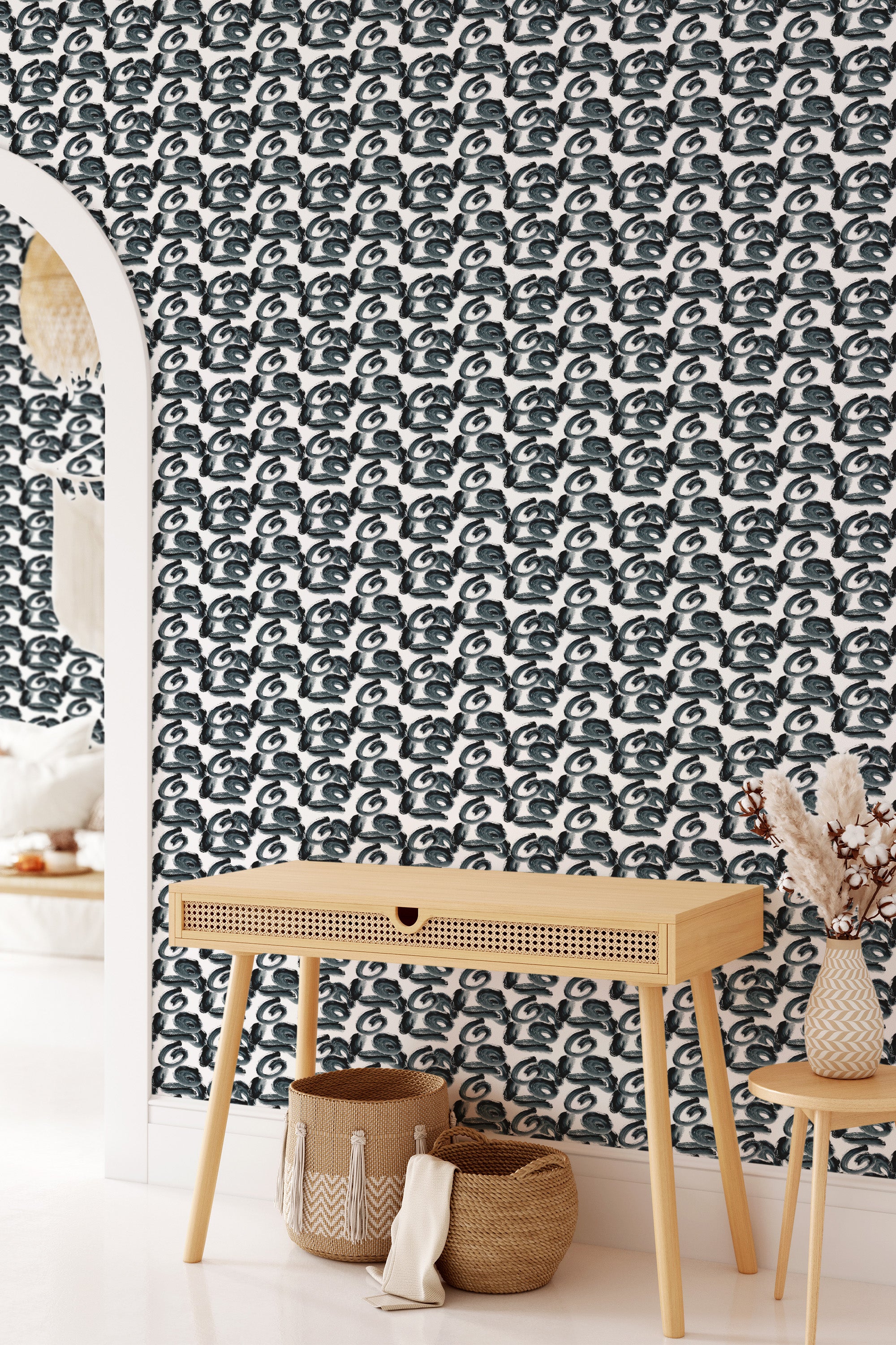 A room with a wall covered in monochrome brushstroke patterned wallpaper in a repeating black and white design, combined with a wooden console table and woven accessories, giving a contemporary twist on traditional wallpaper.