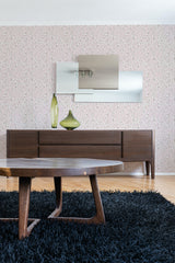 A room with Blooming spring tree wallpaper covering the wall, with pink flowers and delicate branches pattern, above a wooden sideboard and a shaggy blue rug, traditional wallpaper.