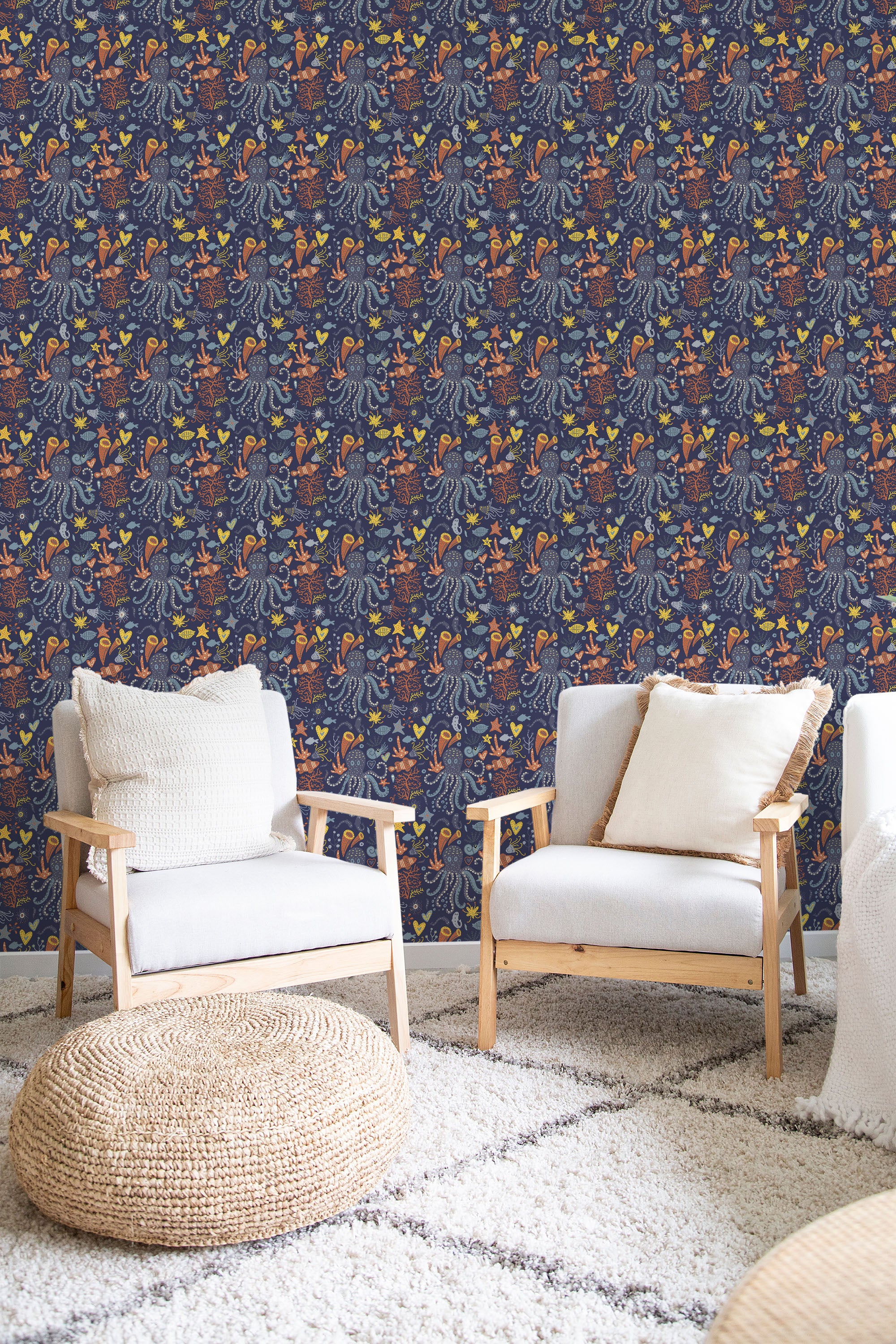 A room with Vintage seaworld-themed wallpaper with blue background and orange sea creature illustrations, complemented by wooden armchairs and a woven ottoman, traditional wallpaper.