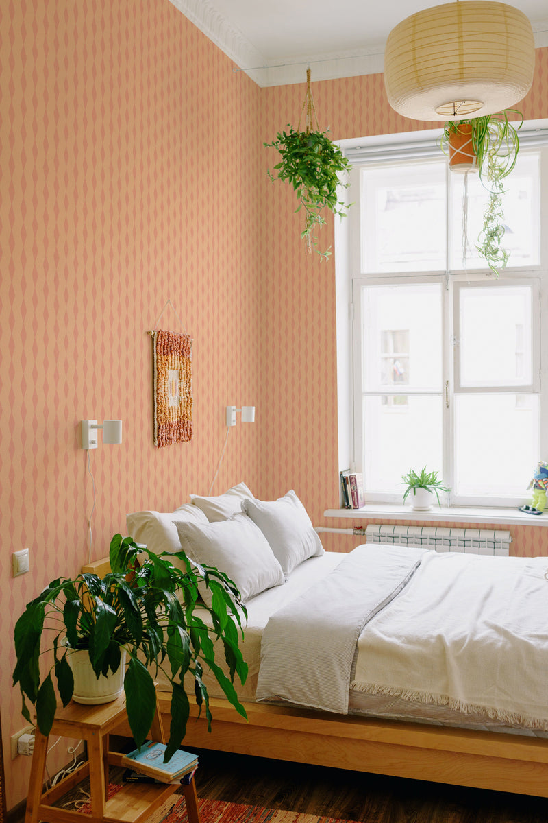 A room with peach-colored Simple rhombus patterned wallpaper on the wall, complementing a wooden bed and green plants, embodying a cozy, traditional wallpaper aesthetic.