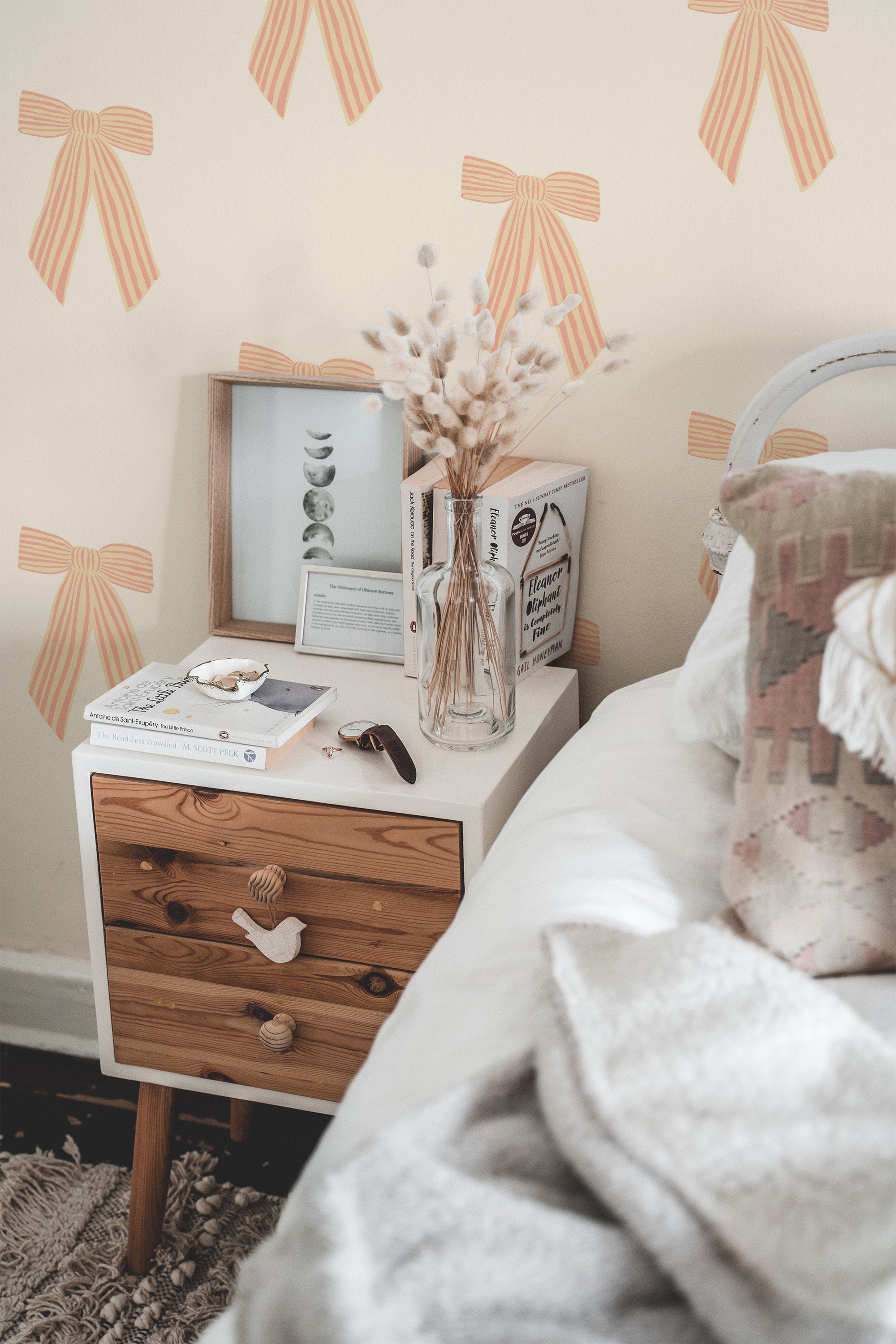 Self-adhesive striped vintage bow wallpaper with pink and cream bows on a light background, decorating a cozy bedroom.