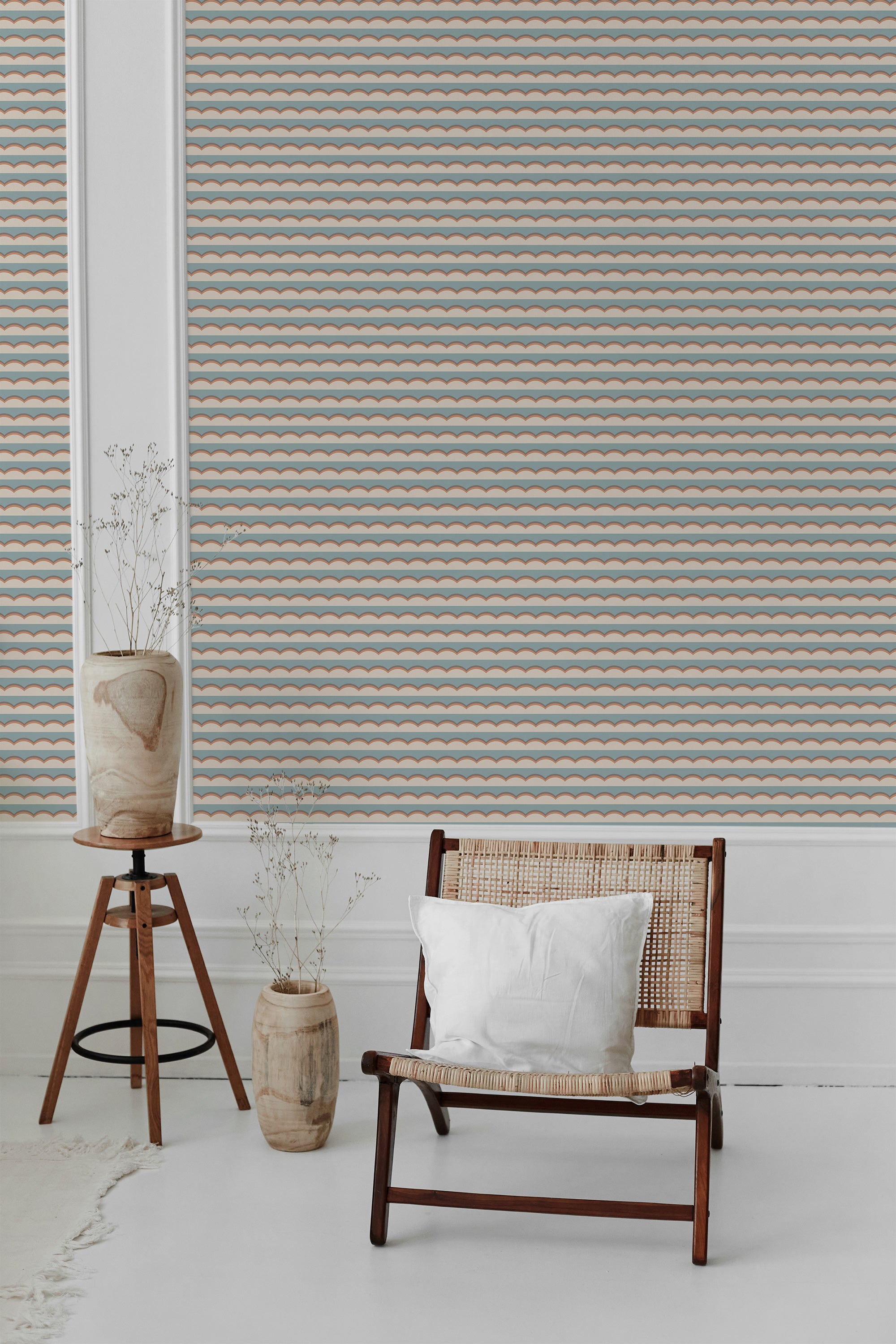 A room with a wall covered in Graphic cloud wallpaper patterned with rows of stylized blue and orange cloud-like shapes on a white background, accompanied by a wooden chair and vase, traditional wallpaper.