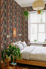 A bedroom with Earthy striped wallpaper with vertical and horizontal lines in muted red, green, and beige tones, complementing the room's natural wood elements and greenery, traditional wallpaper.