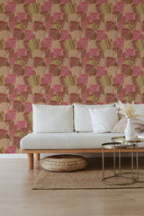 A room with a wall covered in a pink and ocher leaves wallpaper pattern, with a white sofa in front, indicative of traditional wallpaper.