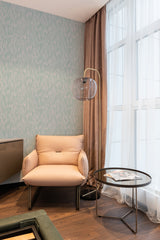 A room with one wall covered in neutral-toned wallpaper sporting a seamless, wavy optical pattern, complemented by sheer curtains and a cozy armchair, traditional wallpaper.