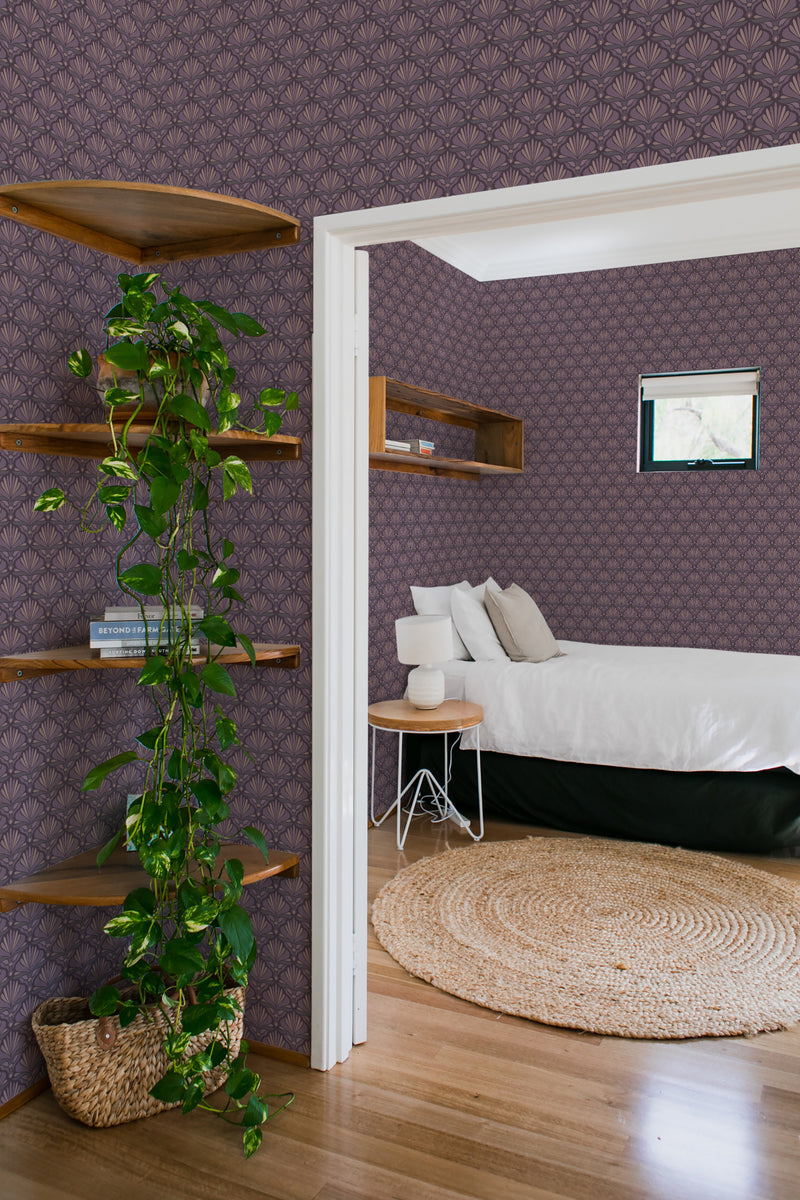 Elegant burgundy wallpaper with an Art Deco-inspired geometric pattern in a bedroom with wooden shelves, a round natural rug, and greenery, complementing a traditional aesthetic.