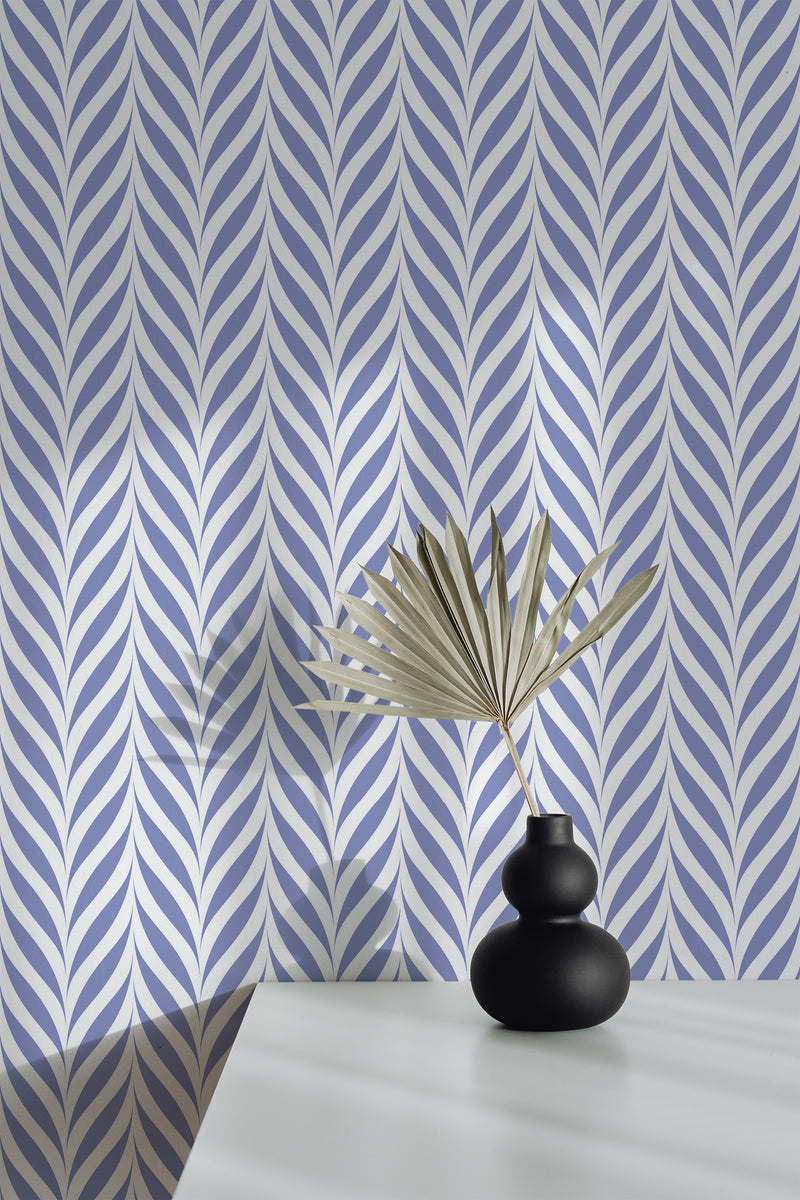 Self-adhesive Elegant Coastal Herringbone wallpaper with a pattern of interlocking blue and gray shapes on a wall, accompanied by a decorative vase with dried palm leaves on a white surface.