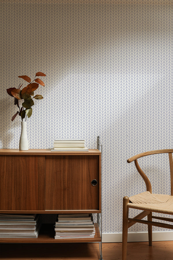 Self-adhesive Small Herringbone pattern wallpaper on a room wall with a wooden cabinet and chair.