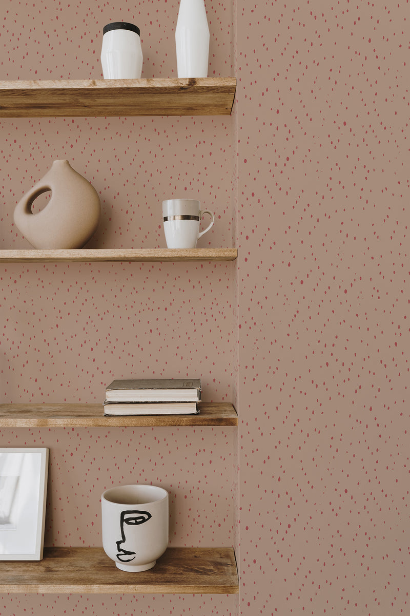 Self-adhesive wallpaper with a pattern of tan background and red spots, accentuating a room with wooden shelves and decorative items.