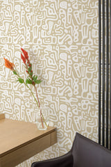 Self-adhesive Honey Abstract Doodles wallpaper with white background and irregular beige line patterns in a room with a wooden table and chair, and a vase with flowers.