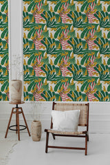 Vibrant wallpaper with a repetitive pattern of stylized tigers, green brushstrokes, and pink florals on a mustard yellow background adorns a room, adding a bold touch to the decor, traditional wallpaper.