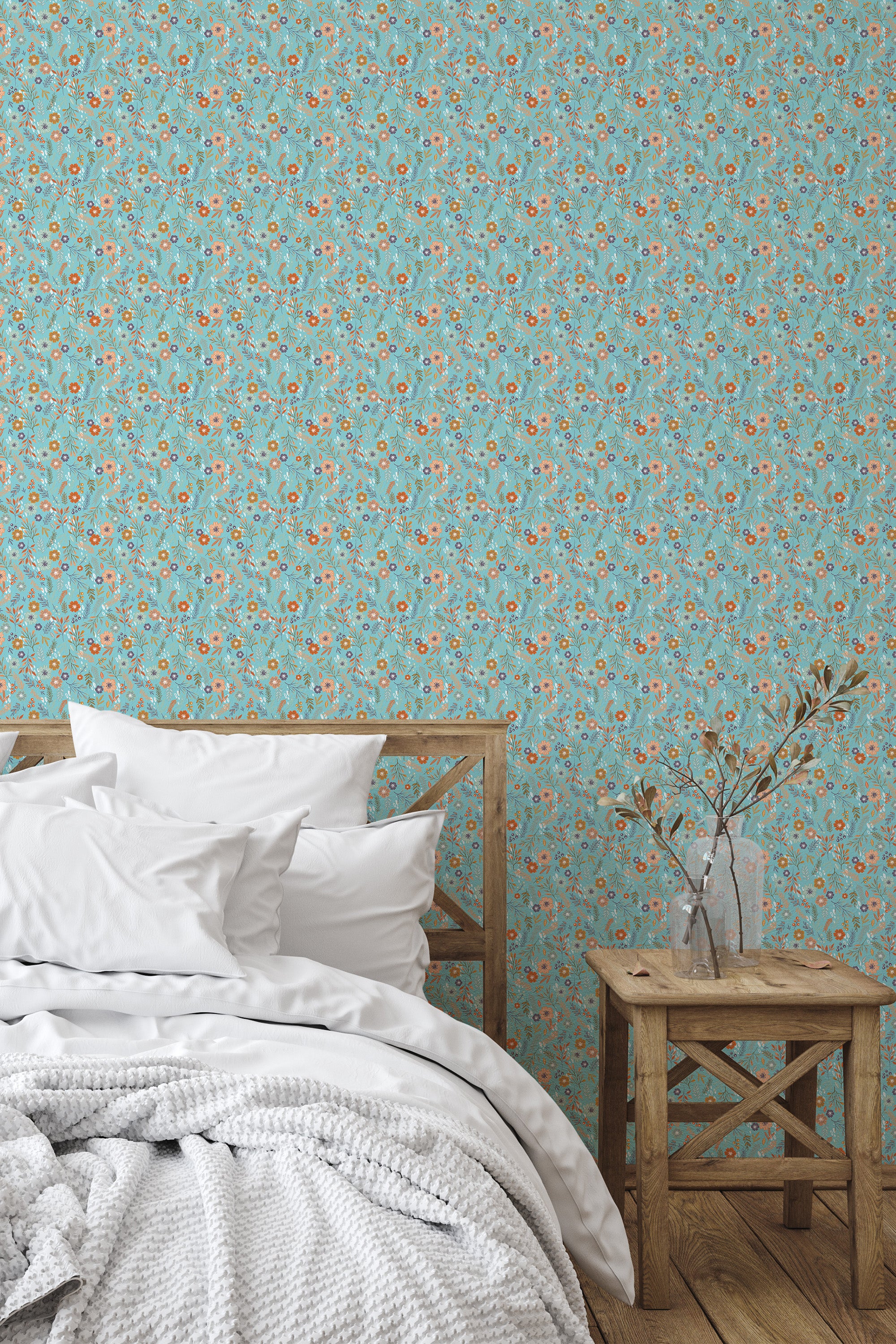 Self-adhesive wallpaper with a repeating pattern of small blue and red flowers on a light turquoise background, covering a bedroom wall behind a bed with white bedding.