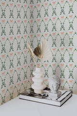 Self-adhesive Country Floral Bow wallpaper with a pattern of green leaves and orange ribbons on a light background, accented by a decorative vase and book on a table.