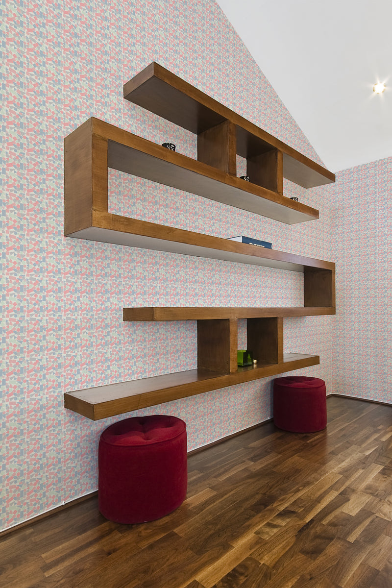 A room with Kids Room Geometry wallpaper with abstract shapes in pastel colors on the walls, complemented by wooden shelves and two red stools, creating a playful yet sophisticated space in traditional wallpaper style.