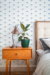 Self-adhesive wallpaper with a Vintage Coastal Palm design on a bedroom wall, including palm motifs and stripes.