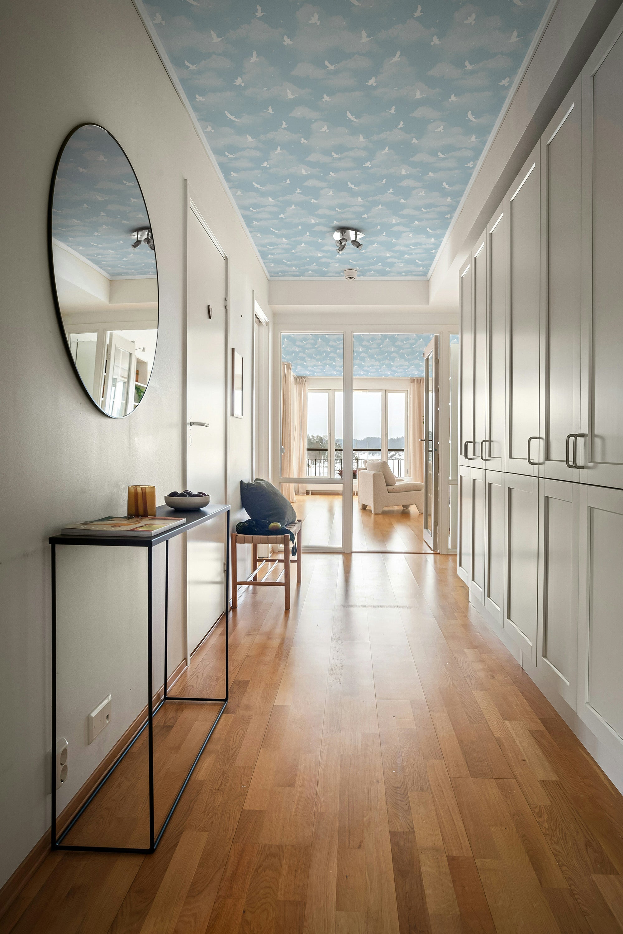 Modern interior hallway with wooden flooring, white walls, and a decorative ceiling.