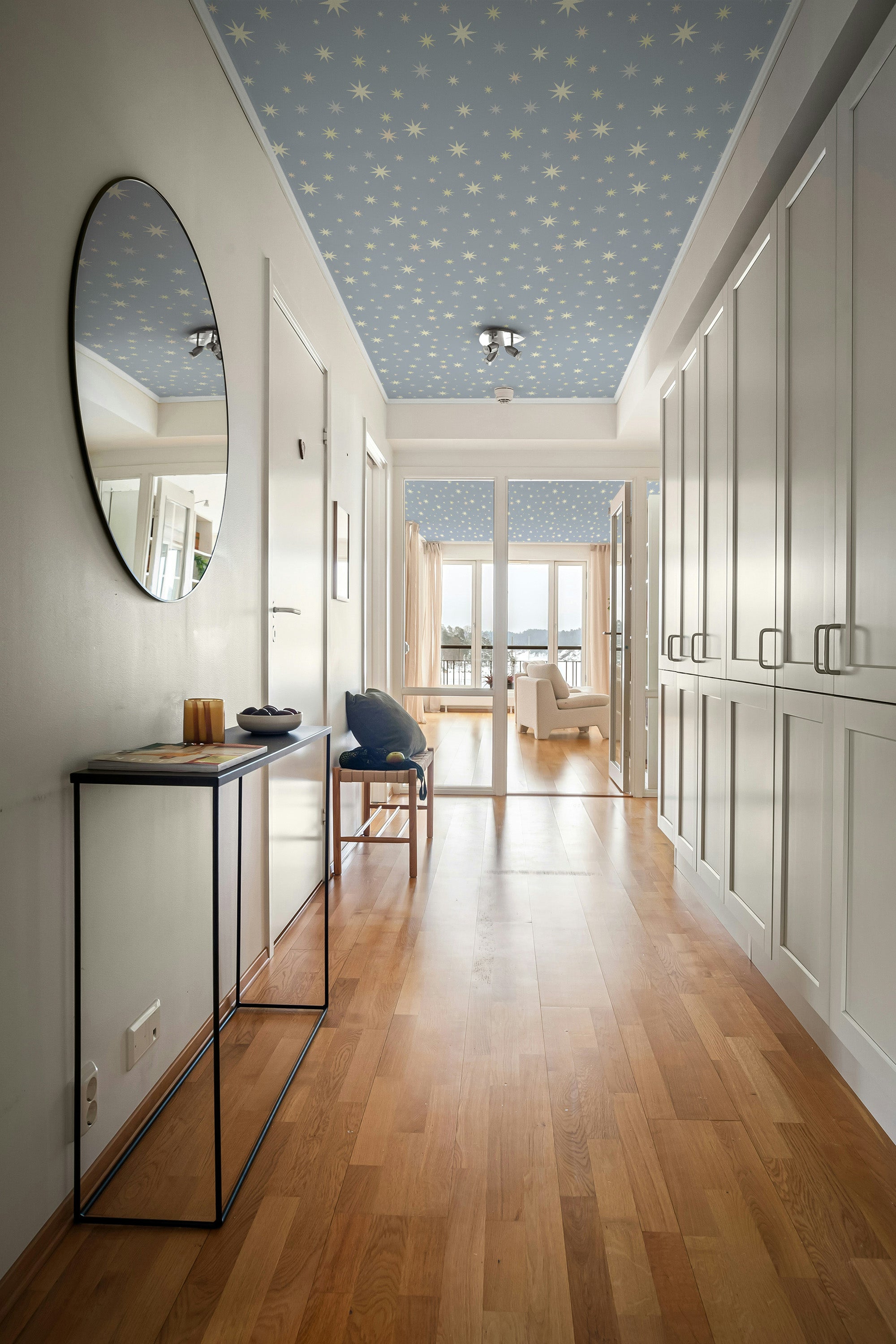 Modern interior hallway with wooden flooring, white walls, and a blue ceiling with star pattern.