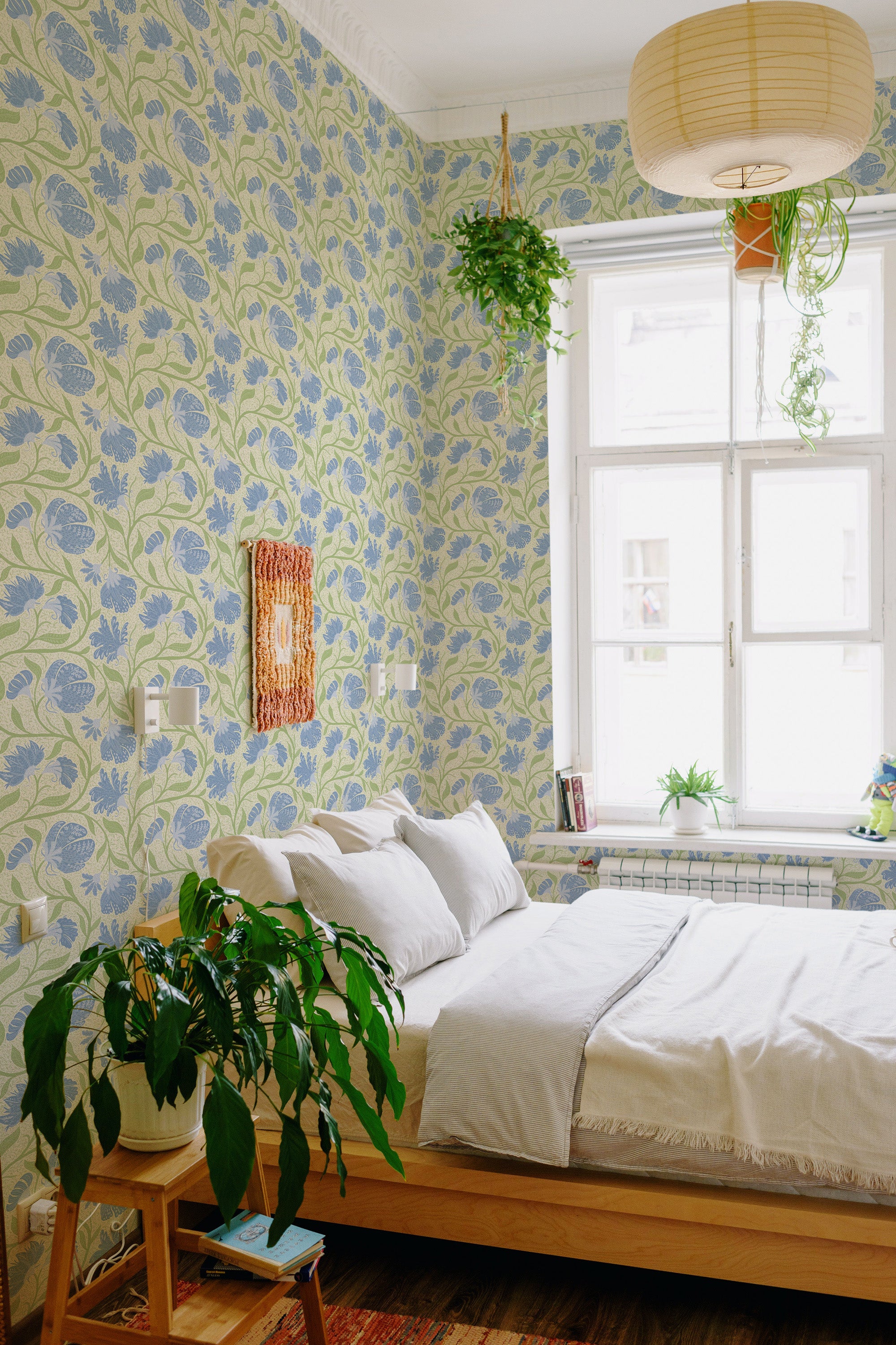 Flowing Floral Vines peel and stick wallpaper in a bedroom, shown as full-wall coverage with blue florals and green vines on cream.
