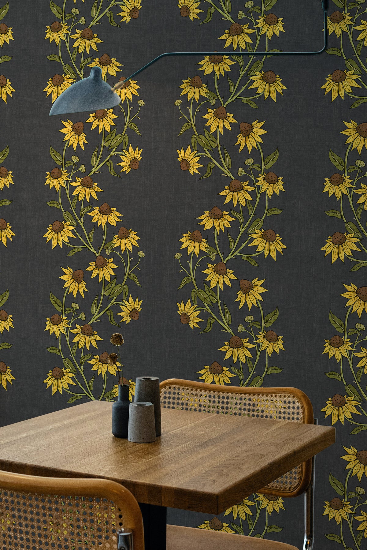 Trailing Sunflowers pre-pasted wallpaper in a dining room, shown on a full wall with yellow sunflower vines on a charcoal background.
