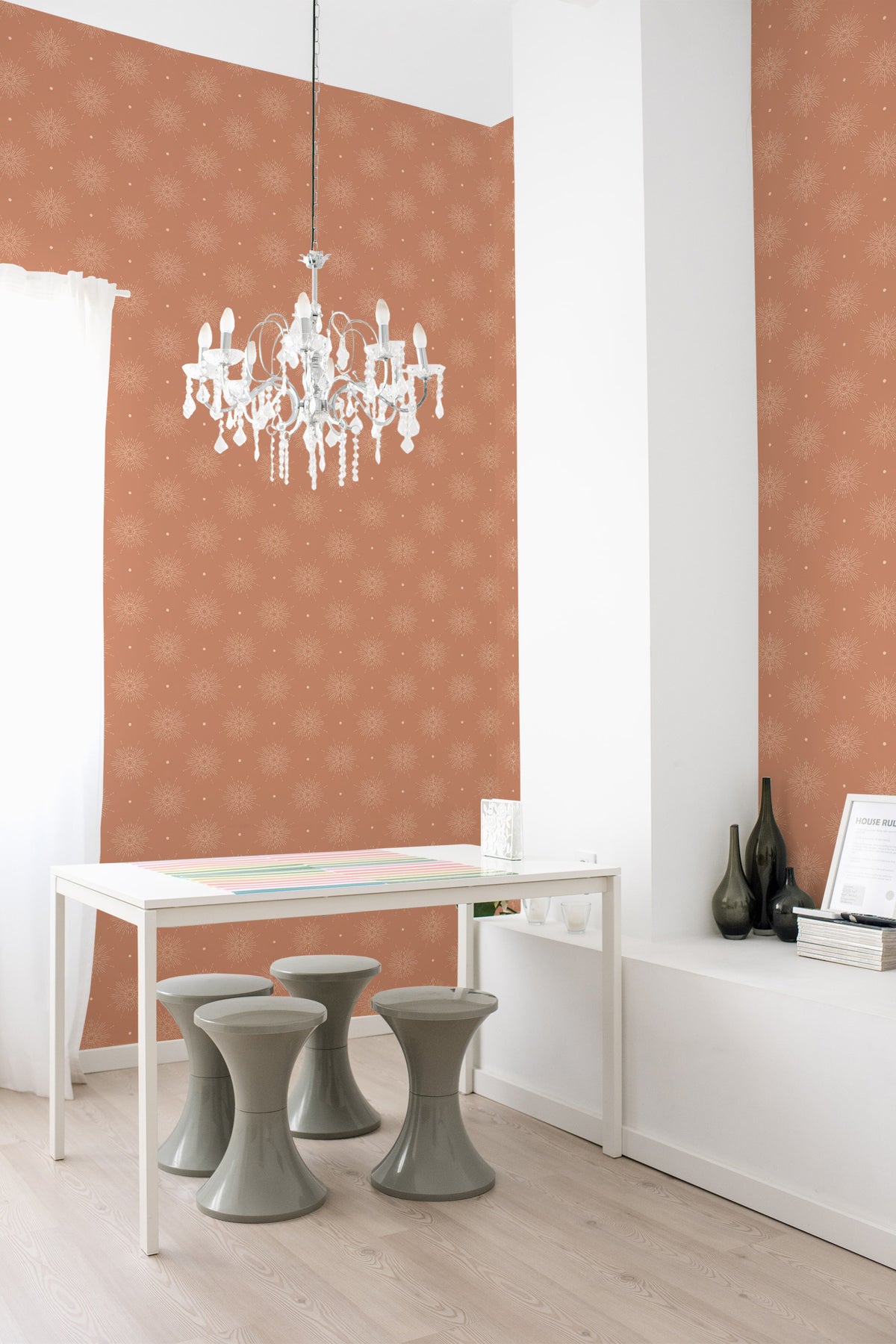 Radiant Sunbursts grasscloth wallpaper in a dining room, shown on full walls with small sunburst motifs on terracotta.