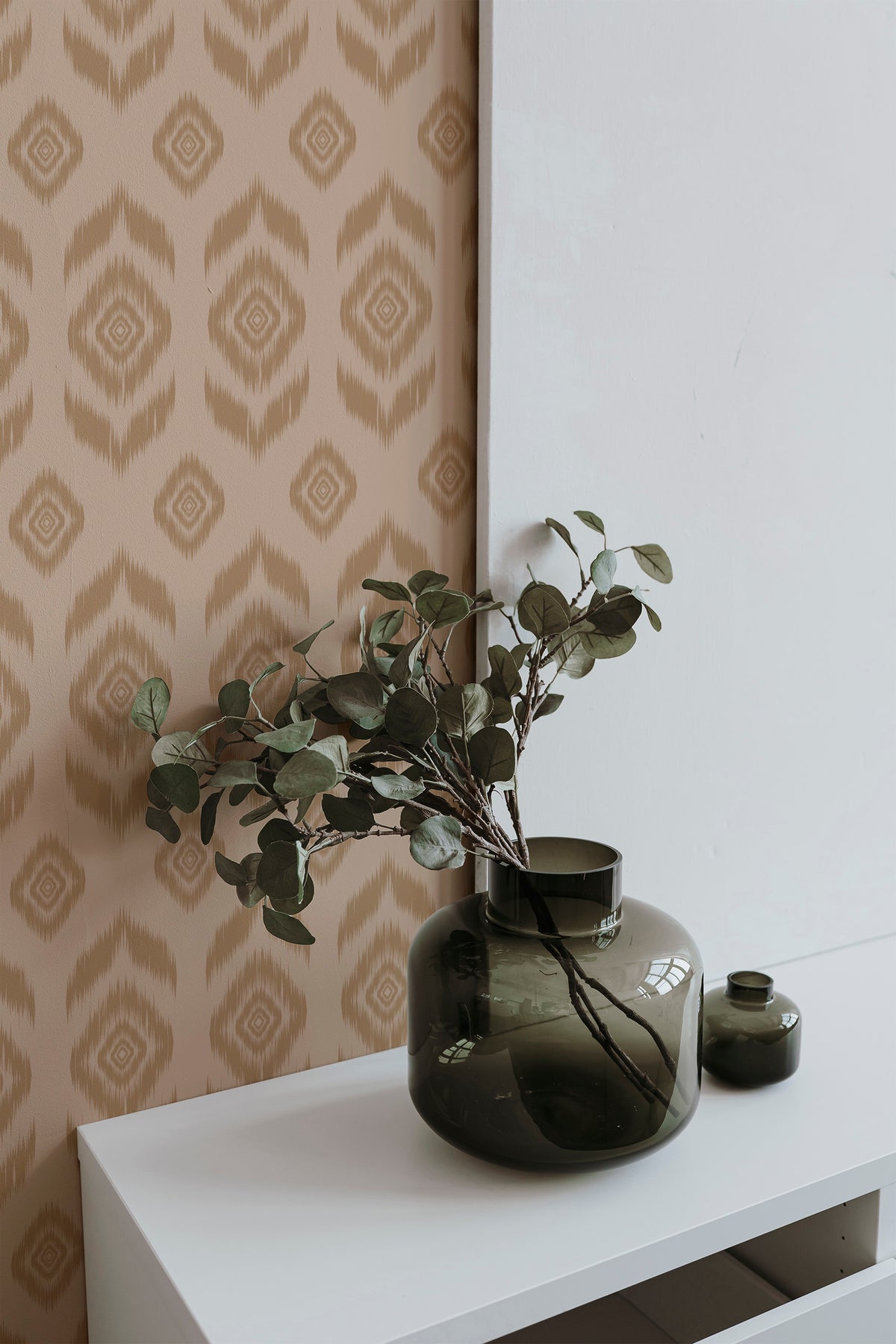 Rustic Ikat Medallions peel and stick wallpaper on an interior wall with tan motifs on a warm beige ground.