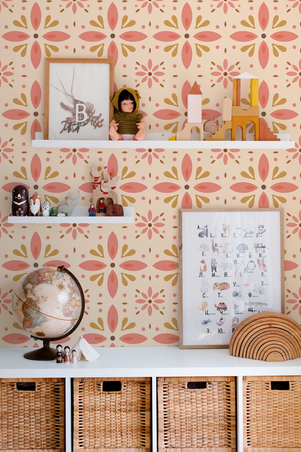 Floralia Medallion grasscloth wallpaper in a nursery with pink and terracotta floral medallions on beige.