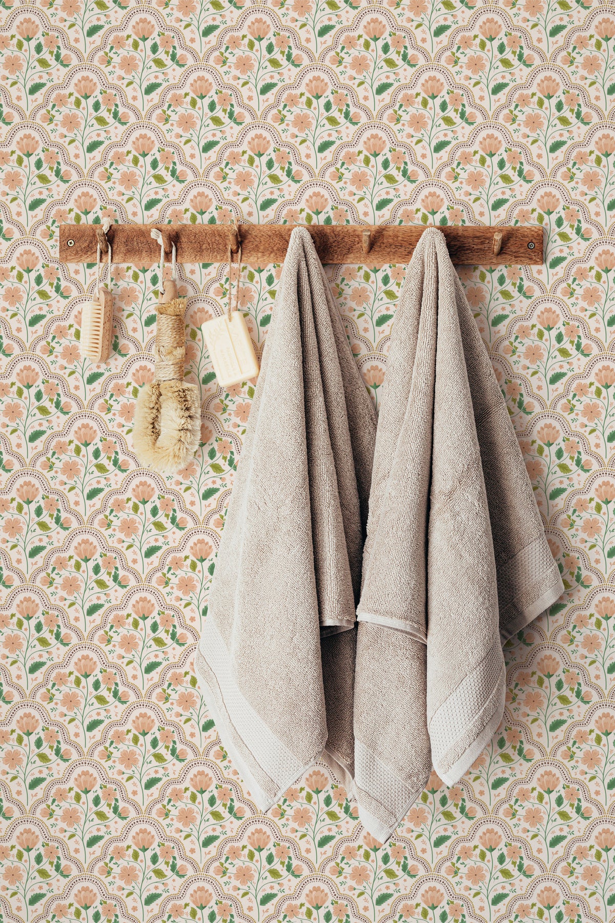 Ornate Trellis peel and stick wallpaper in a bathroom, scalloped floral arches in peach and green on cream.