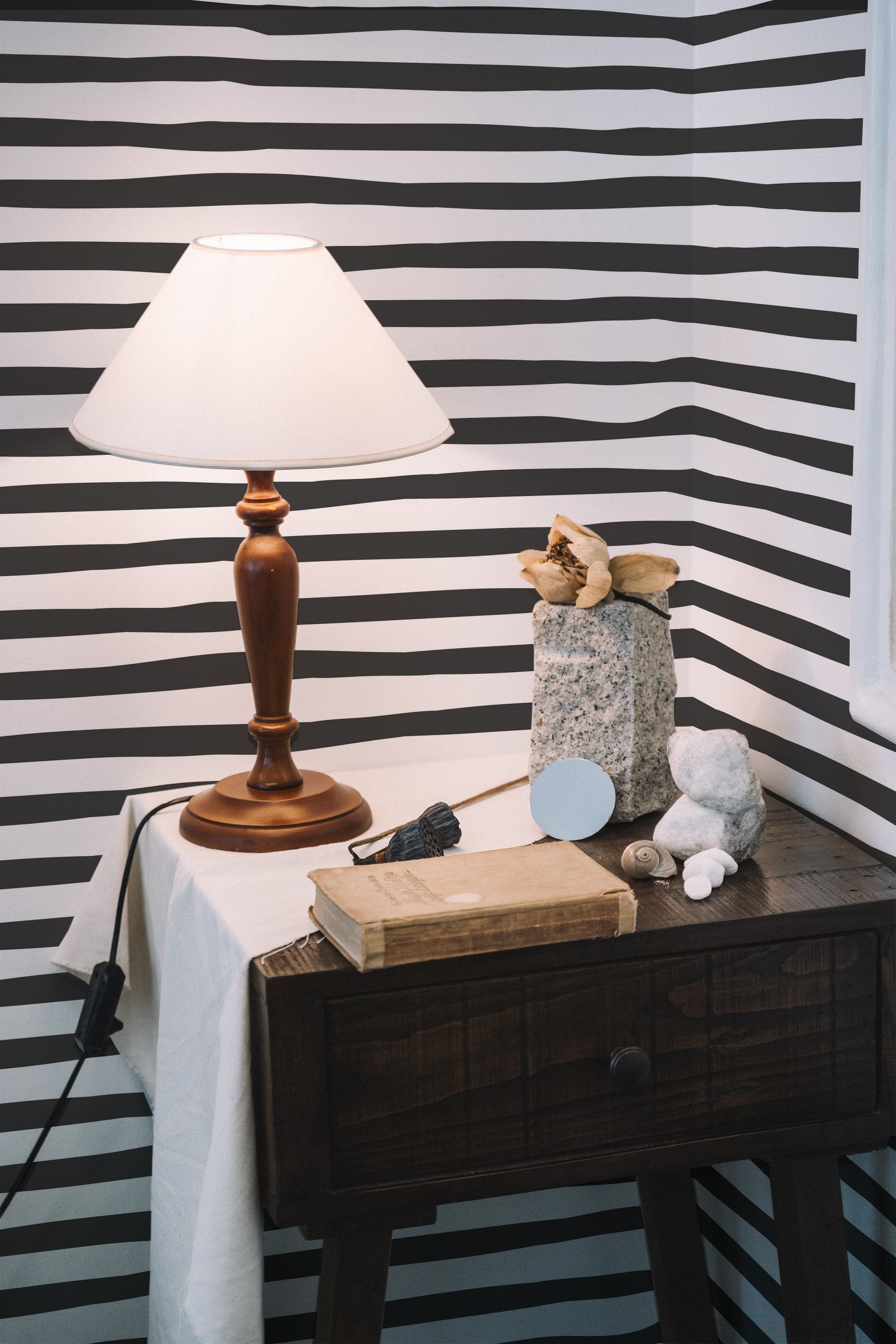 Self-adhesive wallpaper with bold, alternating black and white horizontal lines, creating a modern and dynamic visual pattern on the wall.