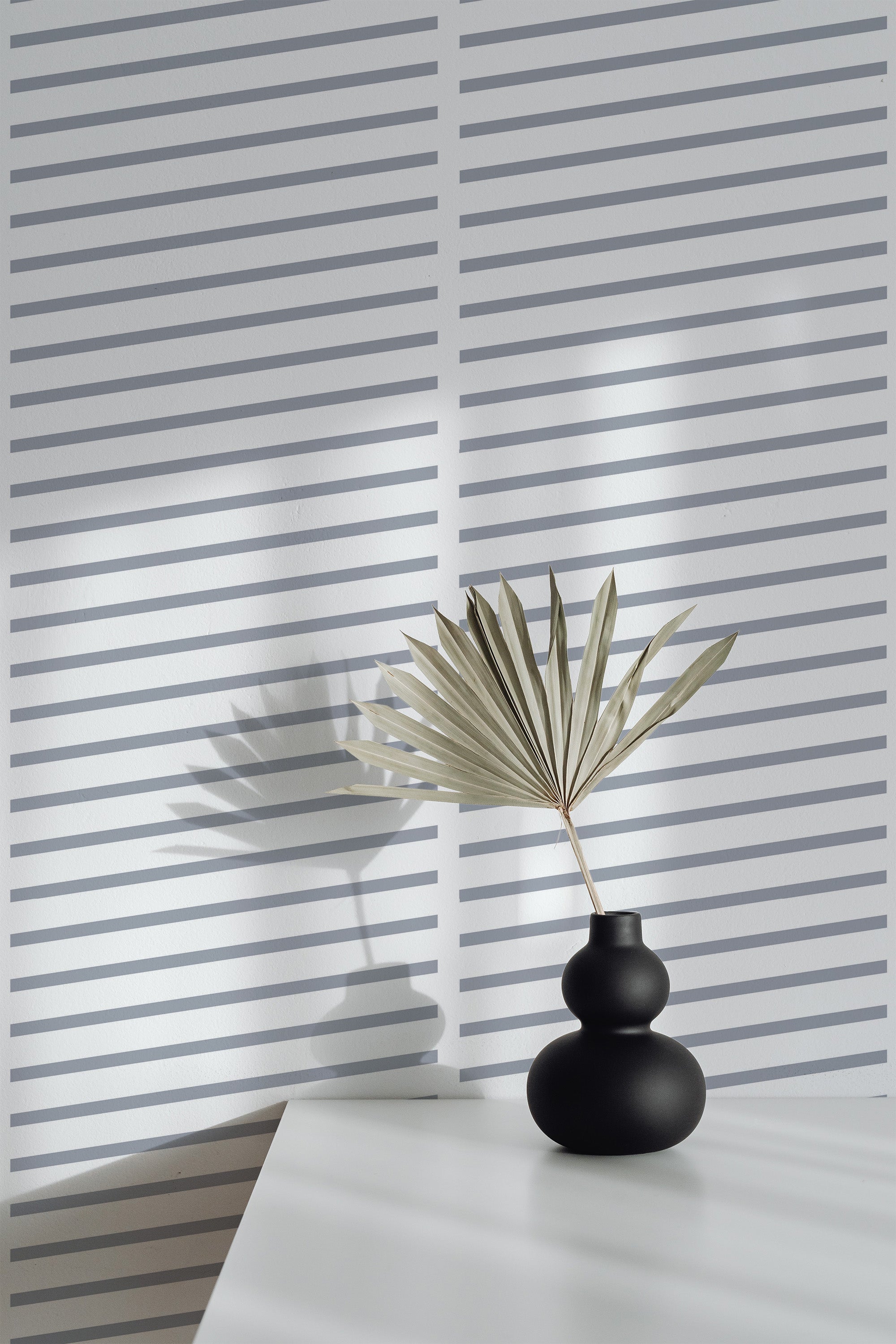 Self-adhesive wallpaper with a pattern of evenly spaced, horizontal, thin dark lines on a light background, creating a minimalist and modern look.