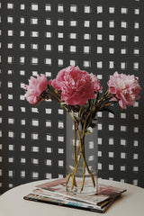 Self-adhesive wallpaper with a Painted Grid design, composed of irregular white squares on a dark background.