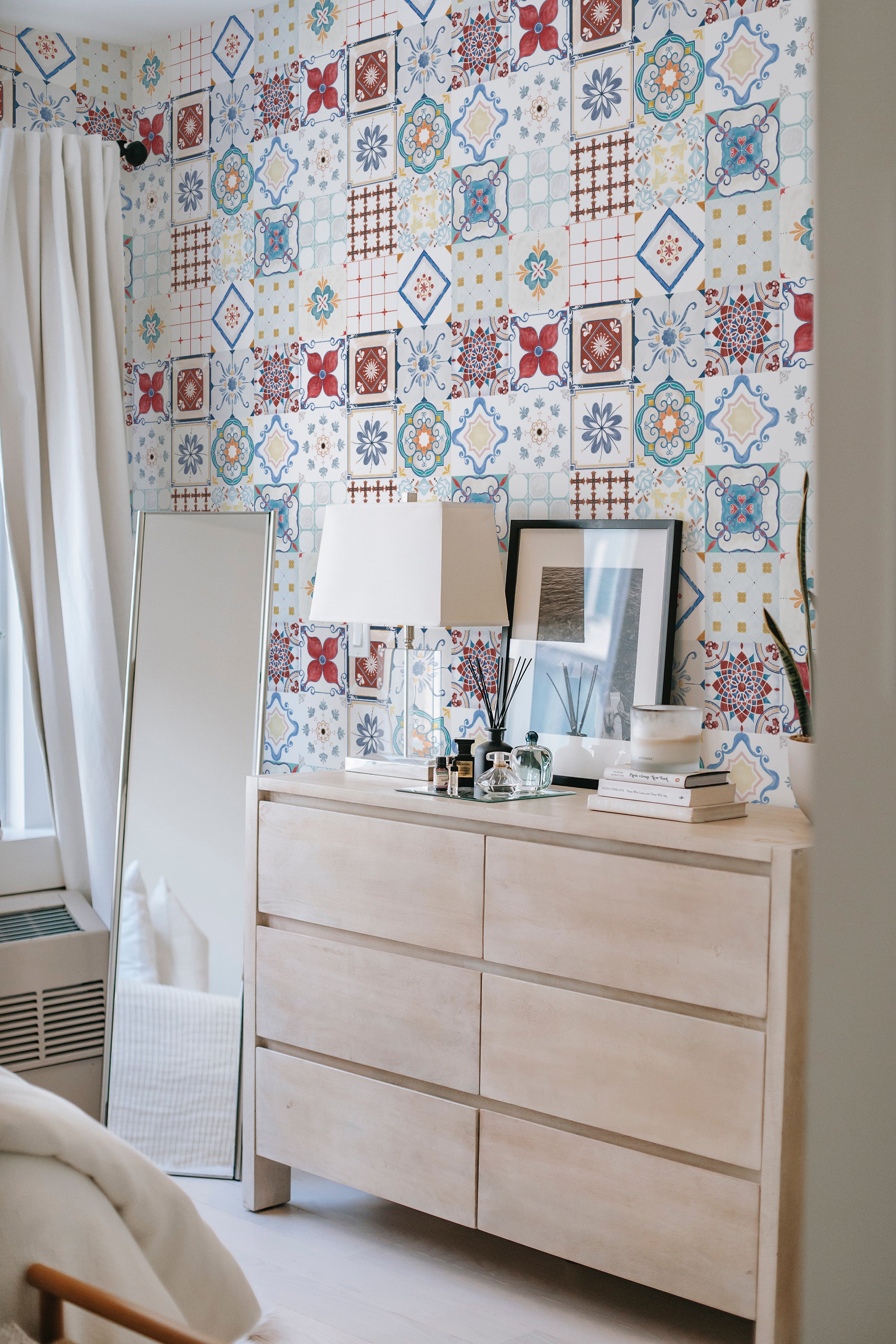 A wall covered with colorful tiles-themed wallpaper featuring a mix of intricate patterns and designs, including floral motifs and geometric shapes in vibrant hues of blue, red, and yellow, giving the room a lively, yet classic, aesthetic. Traditional wallpaper.